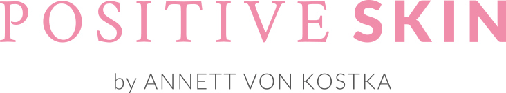 Eine jüngere und ältere Frau sitzen nebeneinander und lächeln in die Kamera